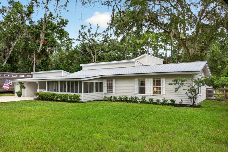 Wide front exterior view of ranch home with metal roof at 1161 Whispering Pines Rd, Jacksonville, FL 32259