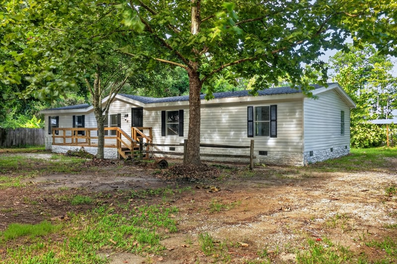 Front exterior with wood porch and wooded lot at 55520 Jewel-Thomas Rd, Callahan, FL 32011