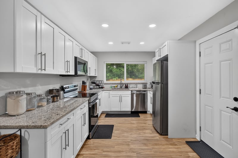 Kitchen with white cabinets and granite counters at 9506 Harriet Ave, Jacksonville, FL 32208
