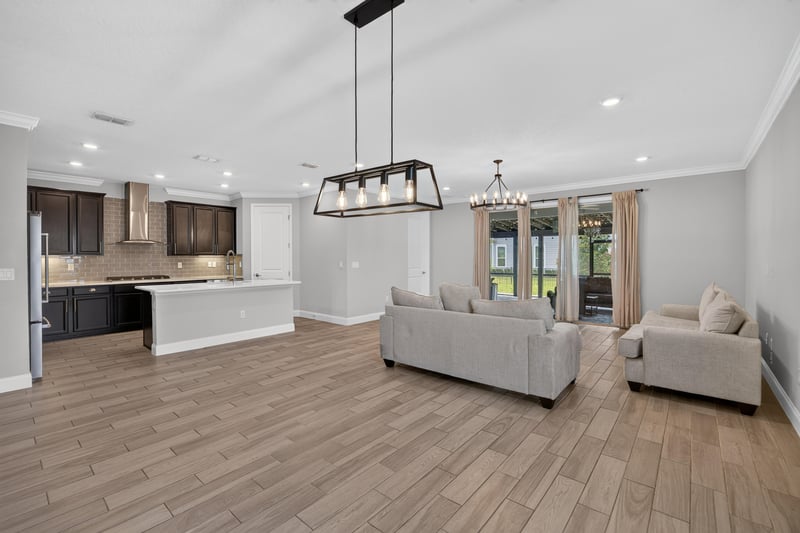 Great room open to the kitchen with linear pendant lights at 91 Tilloo Ct, St. Johns, FL
