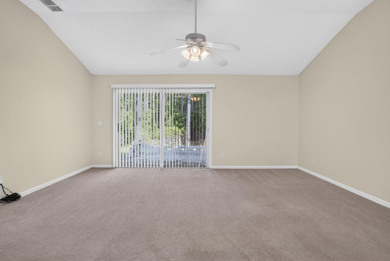 Living room with vaulted ceiling and backyard view at 299 John's Creek Pkwy, St. Augustine, FL 32092