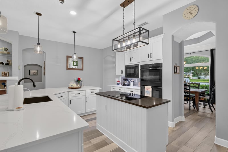 Kitchen island with dark countertop and pendant lights at 2304 Spring Hill Ct, Orange Park, FL