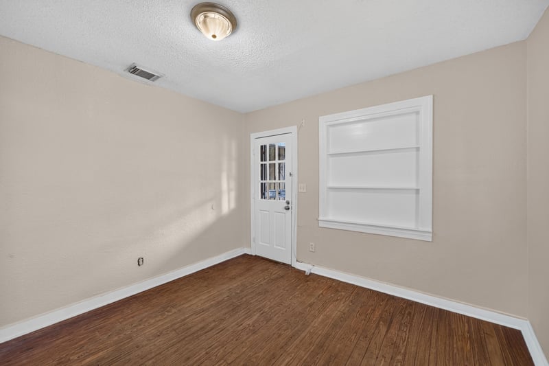 Empty room with wood floors, window and closet door at 1473 State St W, Jacksonville, FL 32209