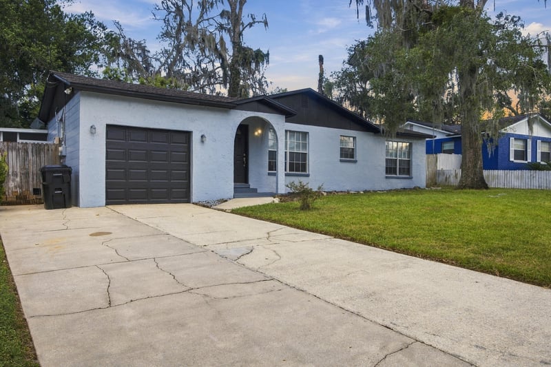 Front exterior with driveway and black garage door at 417 Capricorn Ln, Orange Park, FL 32073
