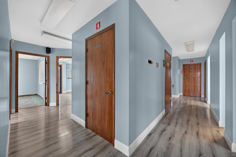 Hallway with wood doors and wood-look flooring at 1543 Kingsley Ave #19, Orange Park, FL 32073