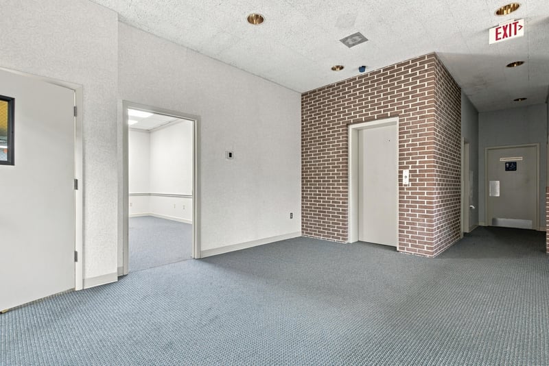 Hallway corridor with carpet and brick accent wall at 101 Scholars Wy