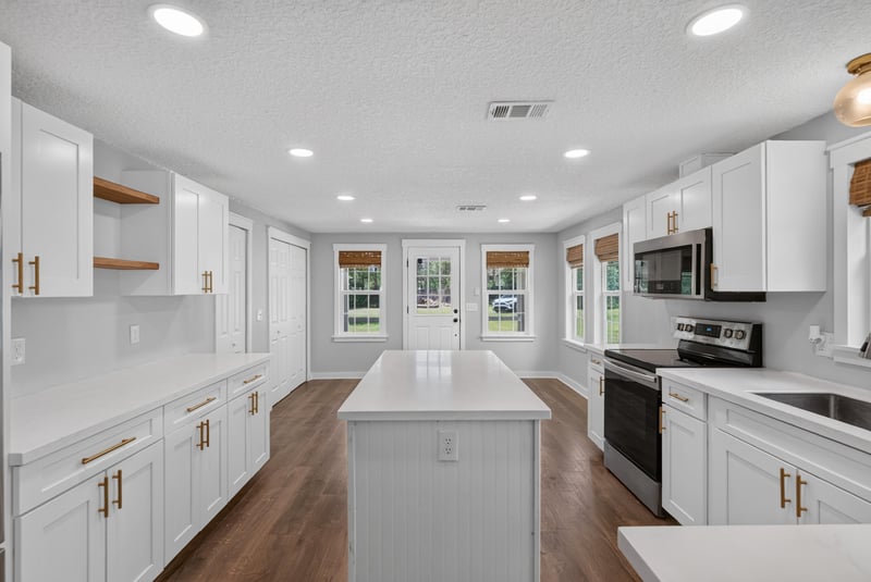 Long kitchen view with island and open shelving at 4890 McAllister Rd, Middleburg, FL 32068