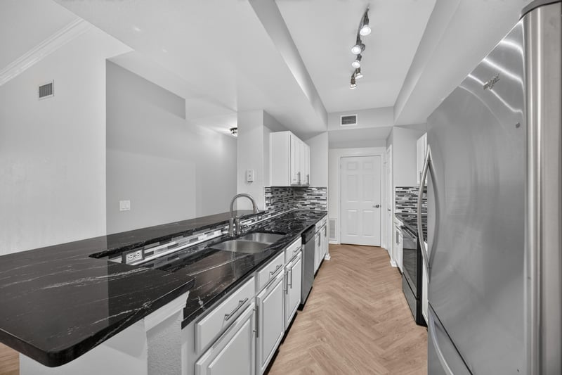 View down the kitchen toward the hallway and refrigerator at 10075 Gate Pkwy unit 1905, Jacksonville, FL 32246