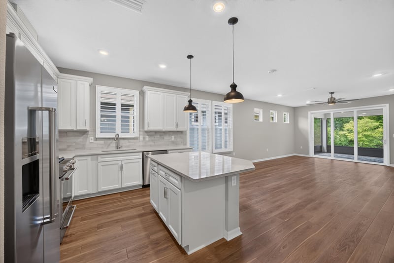 Kitchen island and pendant lights open to the living room at 171 Oyster Shell Ter, Nocatee, FL 32081