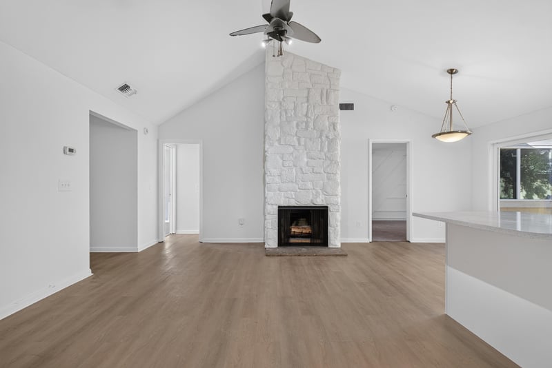 Living room with stone fireplace, unfurnished at 8177 Virgo St, Jacksonville, FL 32216