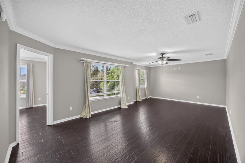Empty room with wood floors and curtained windows at 1493 Greyfield Dr, St. Augustine, FL 32092