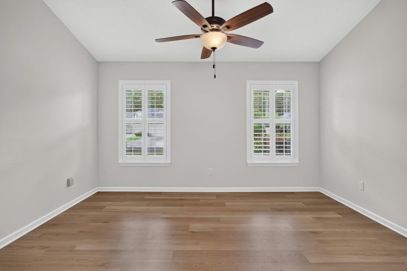 Living room with ceiling fan and large windows at 2131 E Stone Creek Dr, Fleming Island, FL