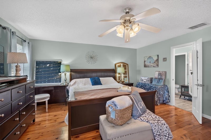 Primary bedroom with closet door and wood flooring at 4556 Shaky Leaf Ln N, Jacksonville, FL 32224