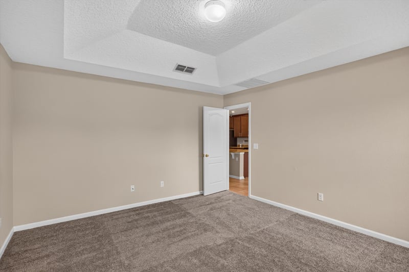 Carpeted bedroom with tray ceiling at 469 Glendale Ln, Orange Park, FL