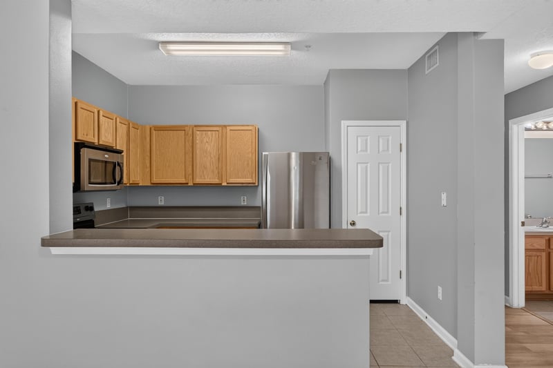 Kitchen counter with microwave and stainless fridge at 575 Oakleaf Plantation Pkwy, Orange Park, FL 32065
