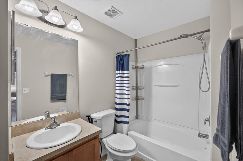 Bathroom with tub-shower combo and striped curtain at 7723 Playschool Ln, Jacksonville, FL