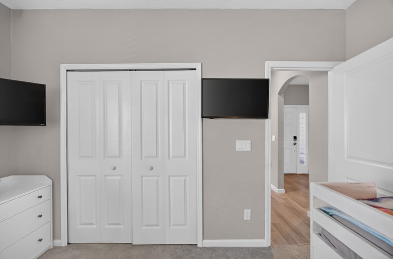 Bunk bed room with closet doors and TV mount at 9942 Lovage Ln, Jacksonville, FL 32219