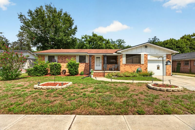 Front exterior with flower bed and driveway at 1847 Grove Park Dr, Orange Park, FL