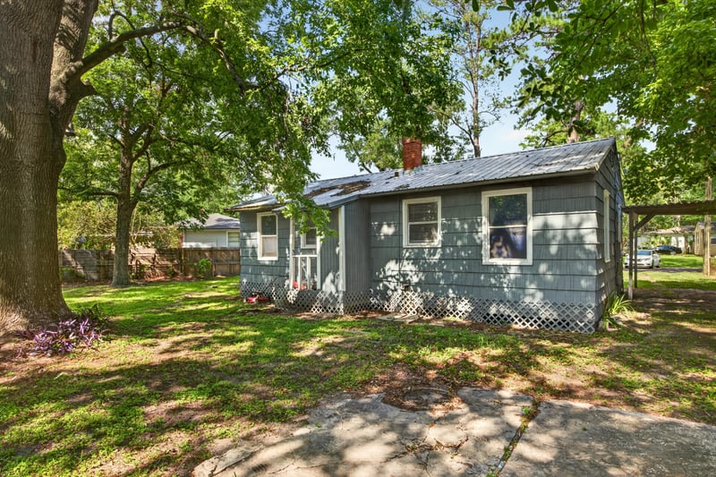 Front exterior with metal roof and trees at 2132 Allandale Cir W, Jacksonville, FL