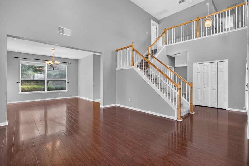 Living room toward staircase with wood railing at 470 Sparrow Branch Cir, Jacksonville, FL 32259