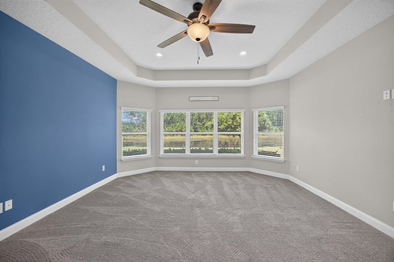 Bedroom corner with blue accent wall and windows at 53 Lumen Ct, St. Augustine, FL 32095