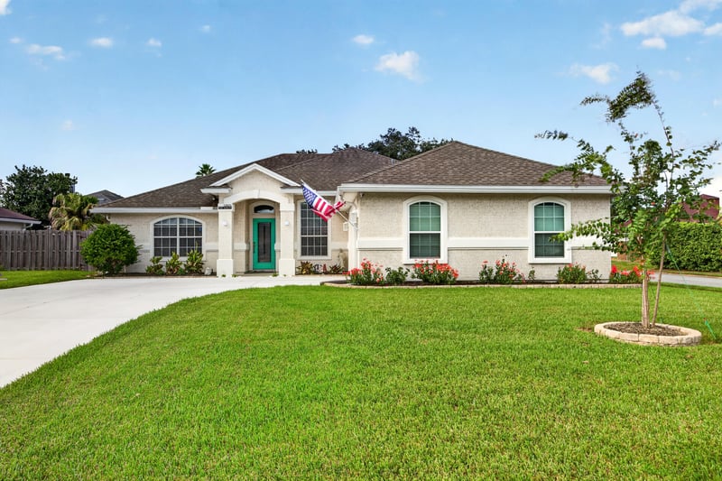 Front exterior view with green door and young tree at 12825 Kelsey Island Dr, Jacksonville, FL 32224