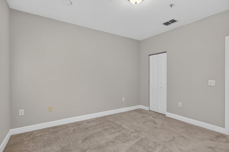 Carpeted bedroom with closet door at 9745 Touchton Rd, Jacksonville, FL 32246