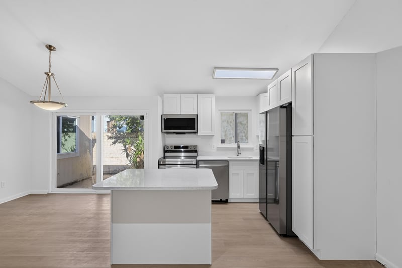 Kitchen island with white cabinets, virtually staged at 8177 Virgo St, Jacksonville, FL 32216