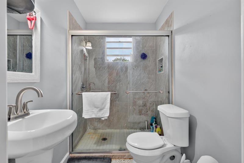 Bathroom with step-in shower and pedestal sink at 5745 110th St, Jacksonville, FL 32244
