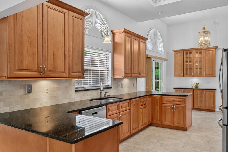 Kitchen cabinets with arched window above sink at 12810 Swamp Owl Ln
