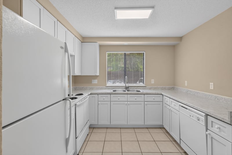 Kitchen with white cabinets and window at 5811 Atlantic Blvd unit 47, Jacksonville, FL 32207