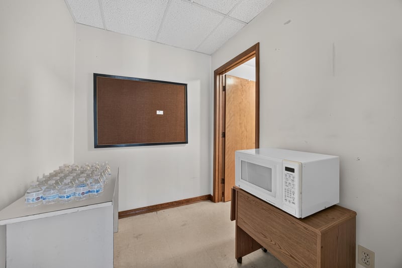 Room with microwave on cabinet and bulletin board at 1543 Kingsley Ave #19, Orange Park, FL 32073