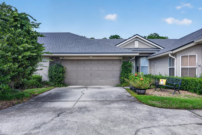 Front exterior with two-car garage and landscaped walkway at 2131 E Stone Creek Dr, Fleming Island, FL