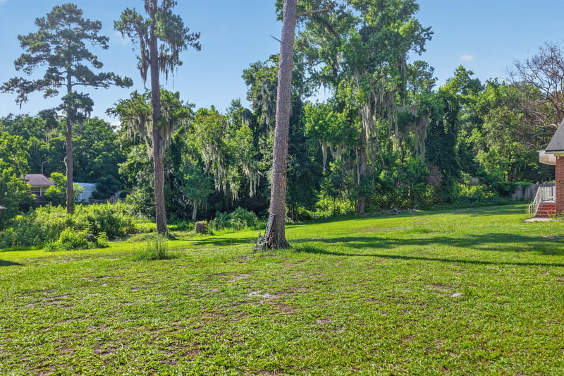 Backyard lawn bordered by trees at 5745 110th St, Jacksonville, FL 32244