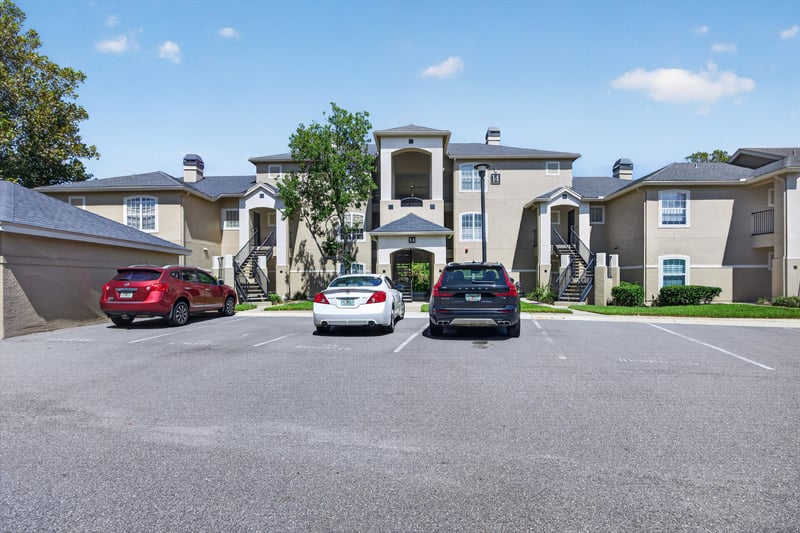 Condo building exterior with parking lot at 1701 The Greens Way 1415, Jacksonville Beach, FL 32250