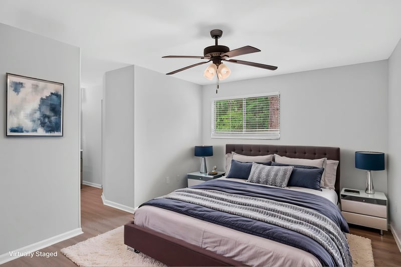 Primary bedroom with bed and ceiling fan, virtually staged, at 3801 Crown Point Rd unit 2061, Jacksonville, FL 32257