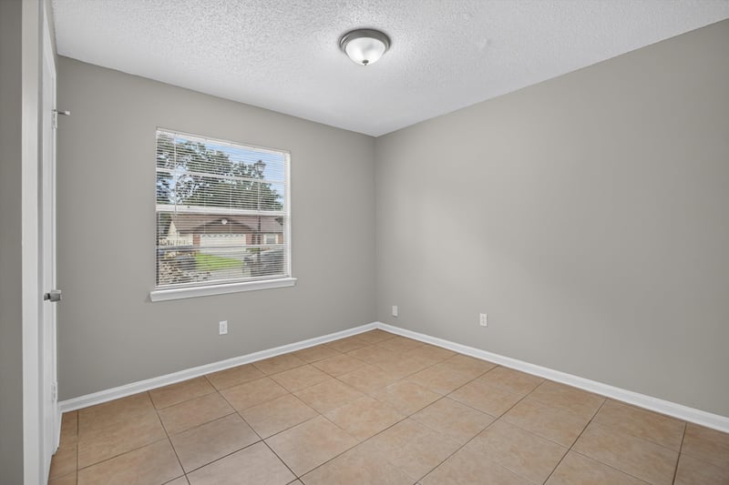 Bedroom with window and tile floor at 1040 Willow Cove Ct E, Jacksonville, FL 32233