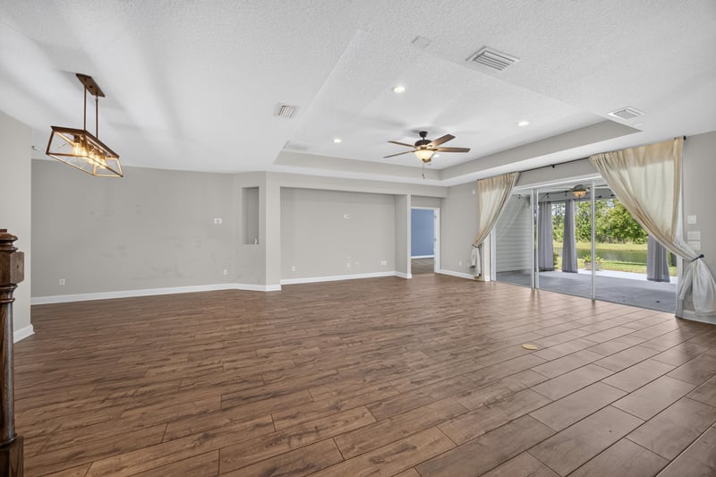 Living room with curtained windows and wood flooring at 53 Lumen Ct, St. Augustine, FL 32095