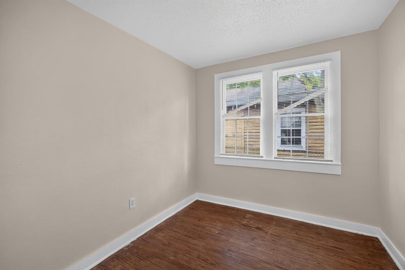 Empty room with two windows and wood floors at 1473 State St W, Jacksonville, FL 32209