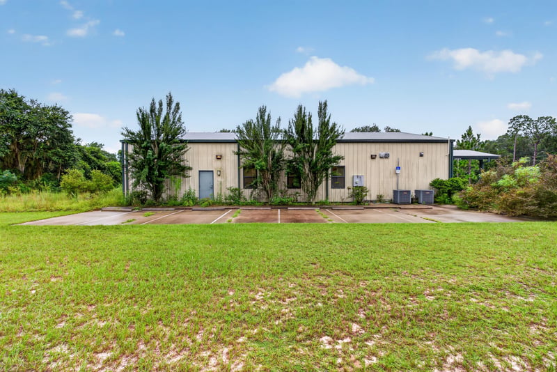 Exterior of a second white metal building with parking area at 1038 County Rd 315, Melrose