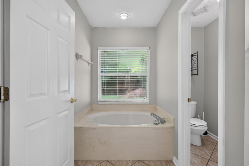 Bathroom with soaking tub and window at 11669 Collins Creek Dr, Jacksonville, FL 32258