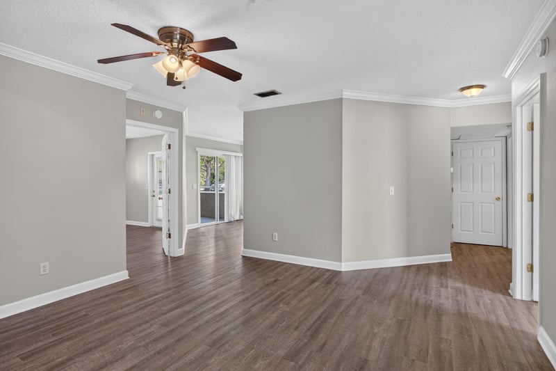 Living room with hardwood floors and multiple doorways at 1701 The Greens Way 1415, Jacksonville Beach, FL 32250