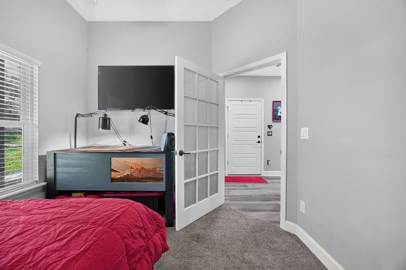 Bedroom with television and red bedspread at 2817 Camel Cir, Middleburg, FL