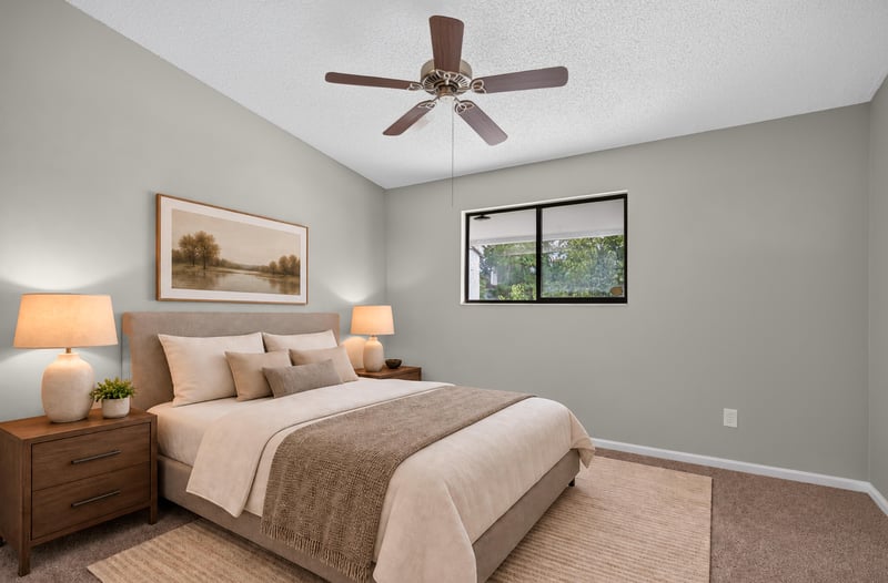 Virtually staged bedroom with bed and ceiling fan at 3801 Crown Point Rd, Jacksonville, FL 32257