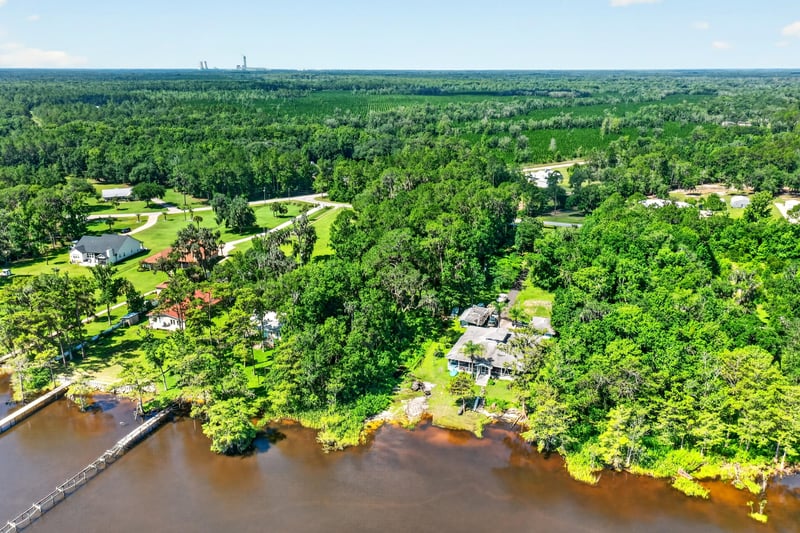 Aerial view of the river shoreline with homes and a pool at 110 River Shores Rd, Palatka, FL 32043