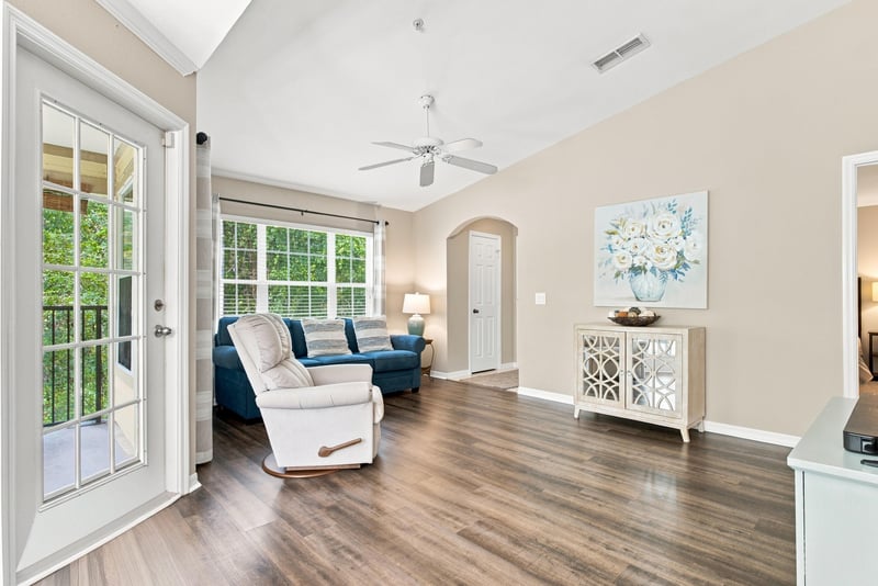 Living room with blue sofa and French doors at 7800 Point Meadows Dr, Jacksonville, FL 32256