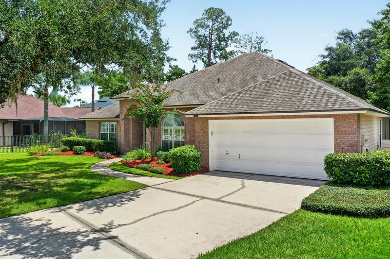 Front exterior with garage and landscaped beds at 1955 GUARDED Way, Fleming Island, FL 32003