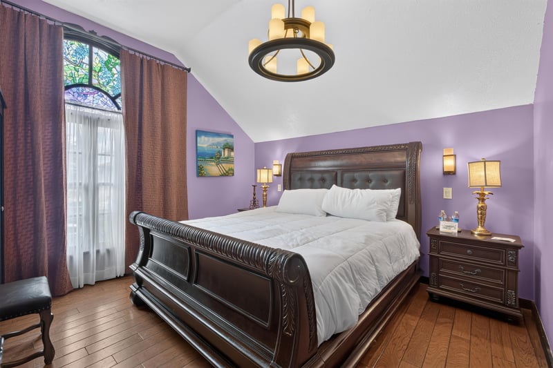 Bedroom with a sleigh bed and vaulted ceiling at 115 Cordova St, St. Augustine, FL