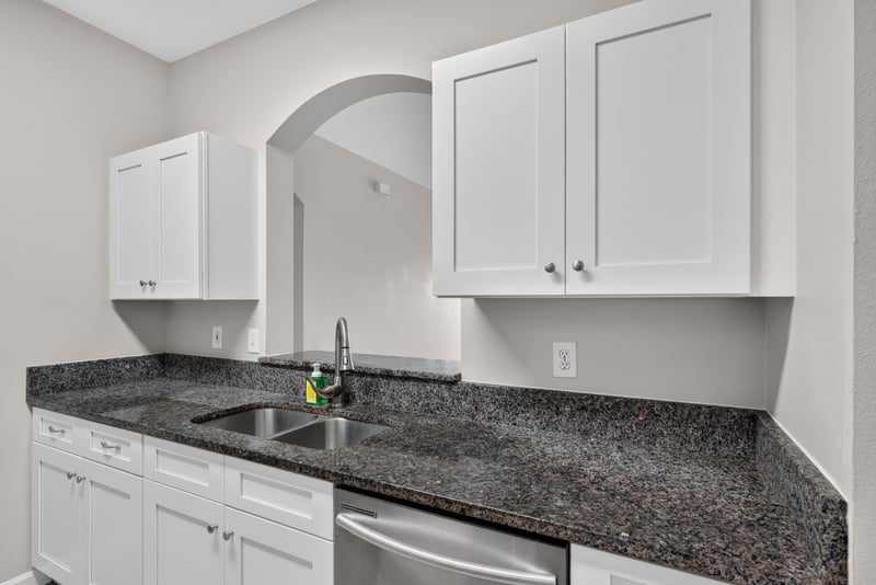 Kitchen sink with granite counter and white cabinets at 7990 Baymeadows Rd E #404, Jacksonville, FL 32256