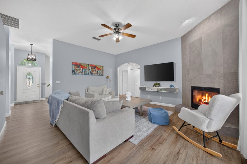 Living room with fireplace and wall-mounted TV at 8921 Needlepoint Pl, Jacksonville, FL 32244